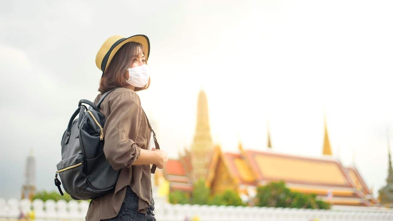 Woman traveling Thailand with a mask on