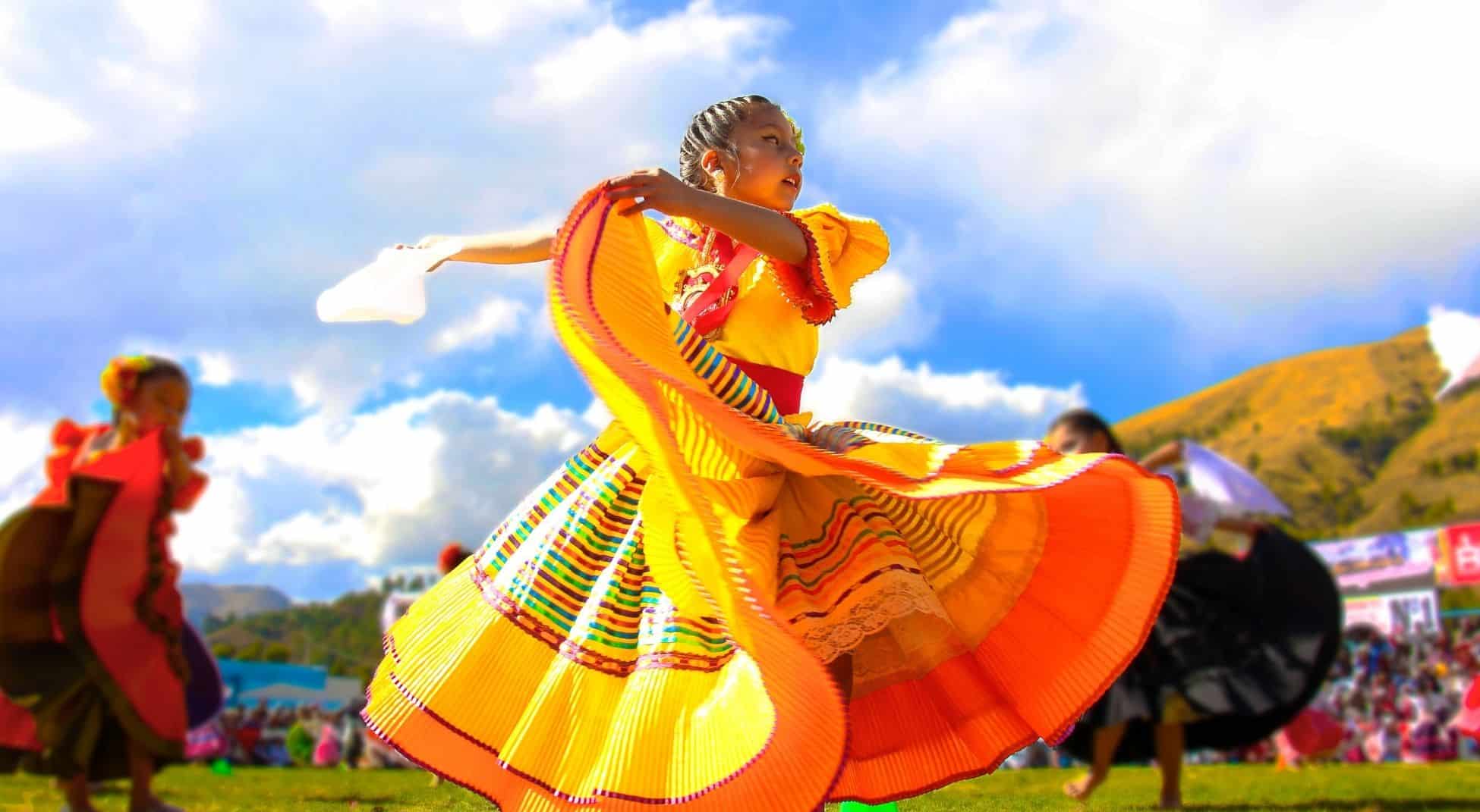 hispanic girl in colorful dress performing traditional dance
