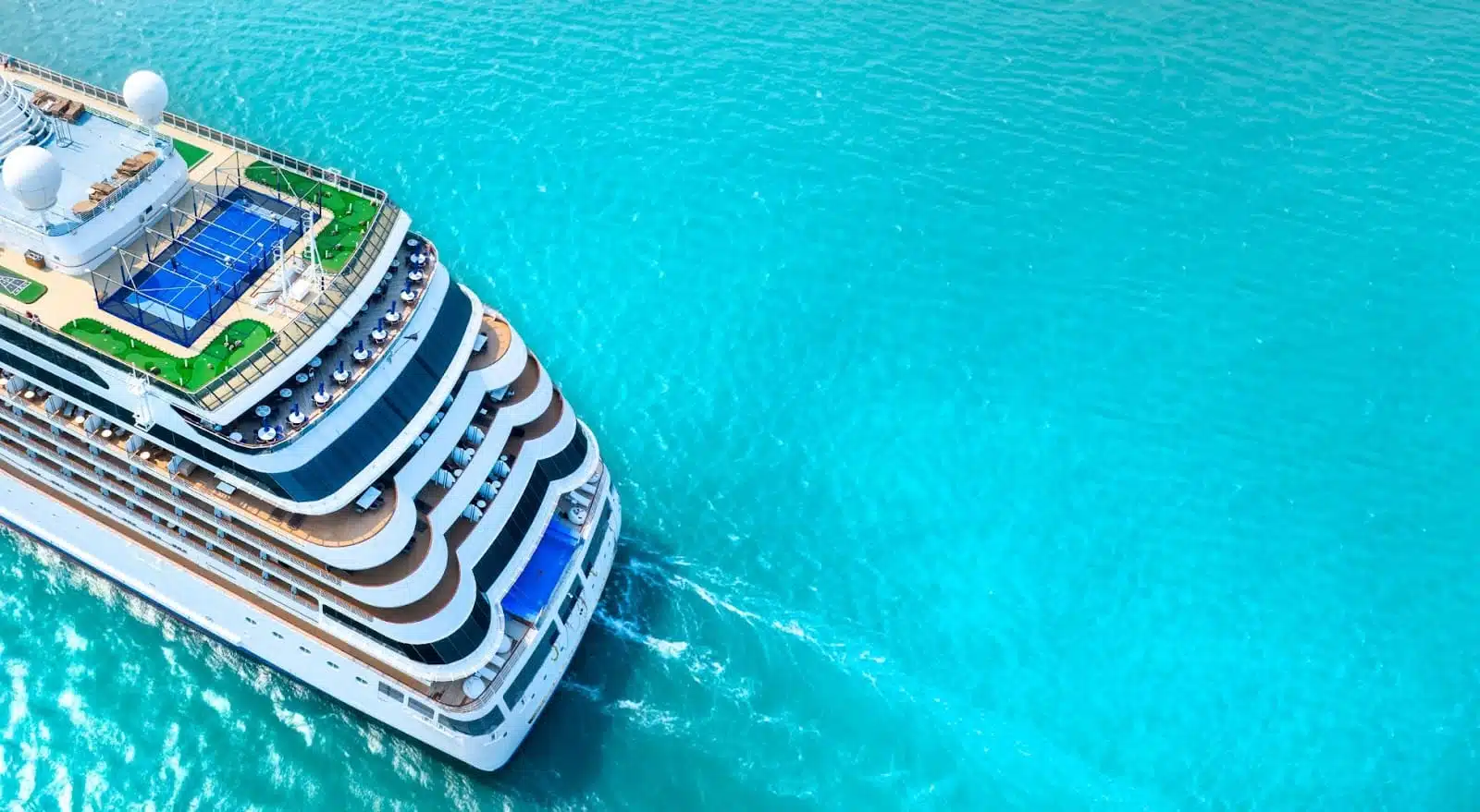 Stern of cruise ship sailing over turquoise blue water