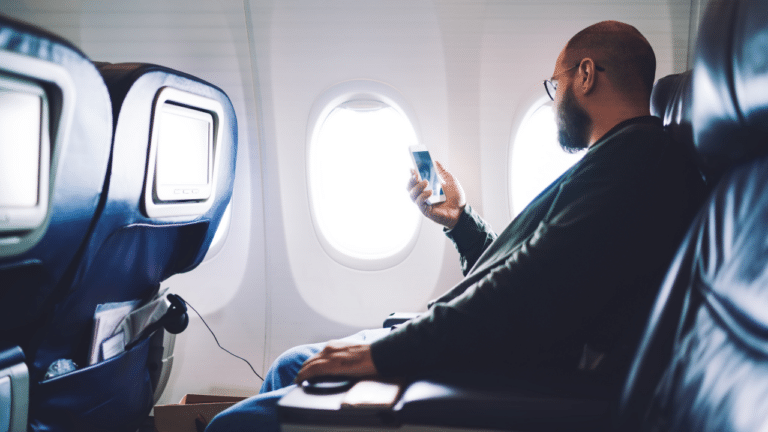 Man-On-Plane-Looking-at-Mobile-Phone