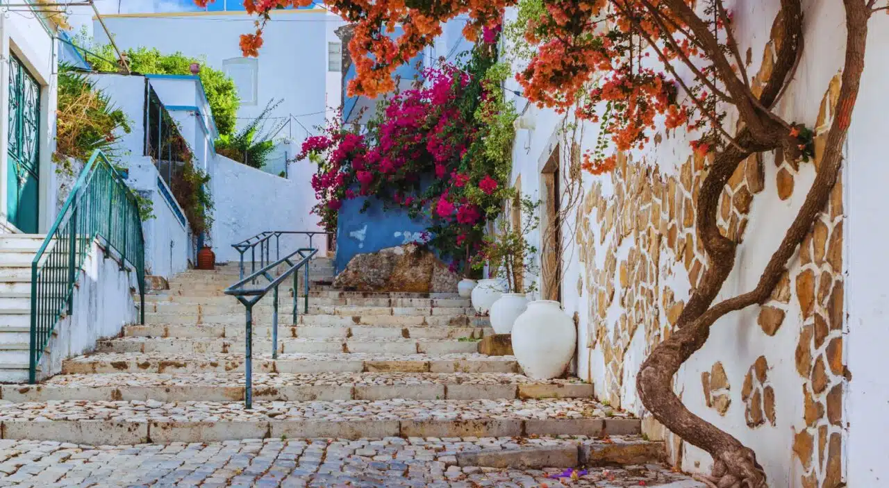 View of street with colorful flowerpots in Estoi village, Portugal