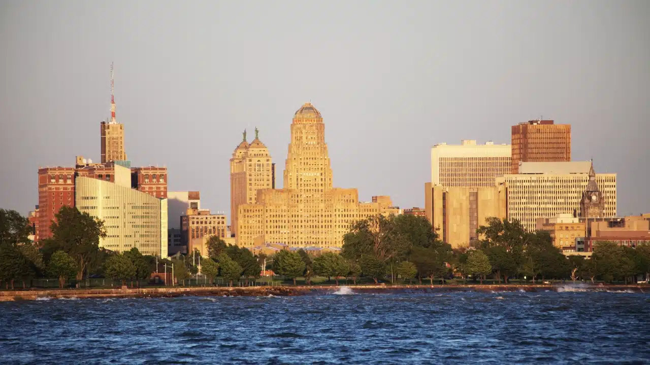 Buffalo, New York skyline at sunset viewed from Lake Erie, featuring historic architecture, modern skyscrapers, and a scenic waterfront along one of the most vibrant cities in Western New York
