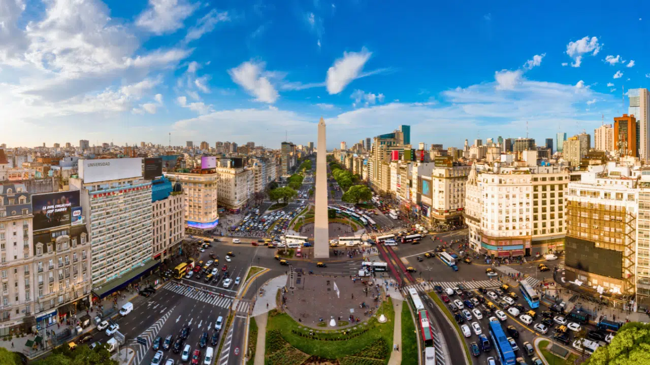 Panoramic view of Buenos Aires, Argentina, highlighting the iconic Obelisk on Avenida 9 de Julio, vibrant city skyline, historic architecture, and lively urban atmosphere, making it one of South America's top travel destinations.