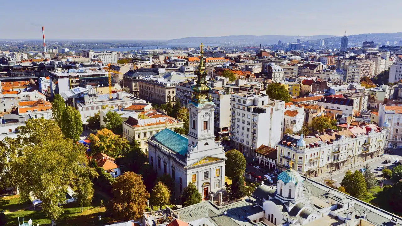 Panoramic view of Belgrade, Serbia, featuring the Church of Saint Sava, historic city architecture, and the Danube and Sava rivers in the distance.